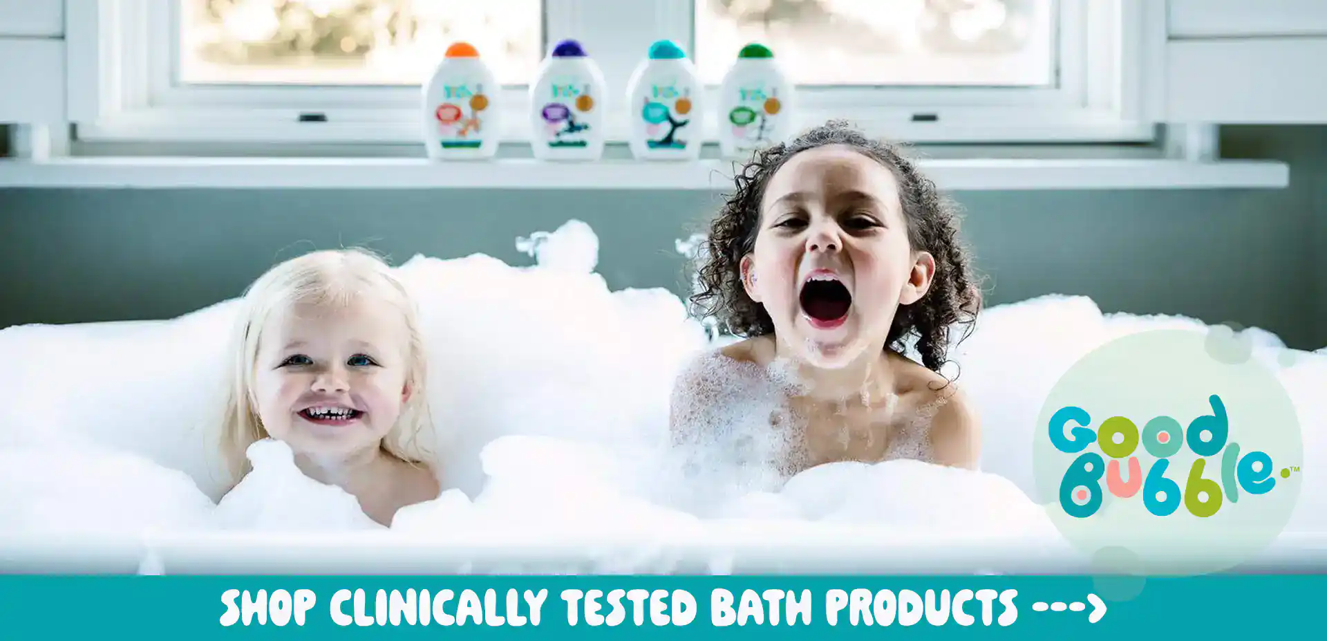 Two children having fun in a bubble bath with Good Bubble products.
