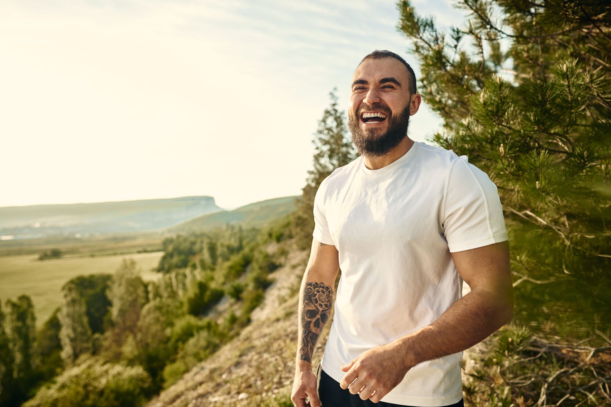 Young bearded man portrait outdoors in the mountains Level up