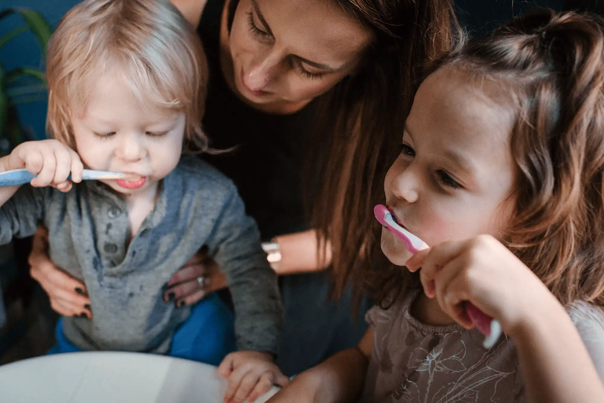 mum brushing teeth with her children