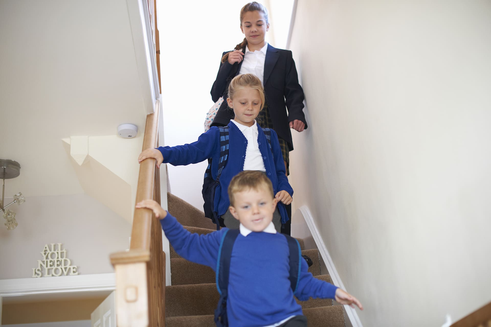Teenage schoolgirl with sister and brother in uniforms moving do Back to school routine
