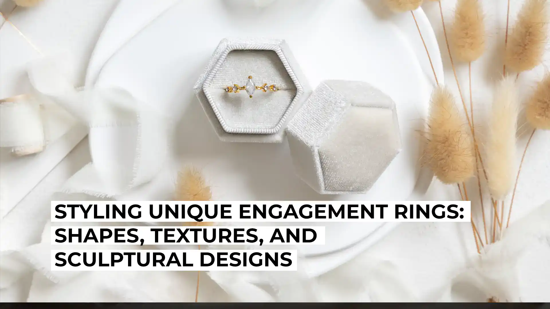 Elegant engagement ring with textured and sculptural design in a hexagonal box.