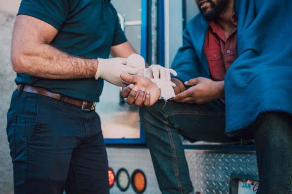 Paramedic treating an injured worker's wrist at a workplace