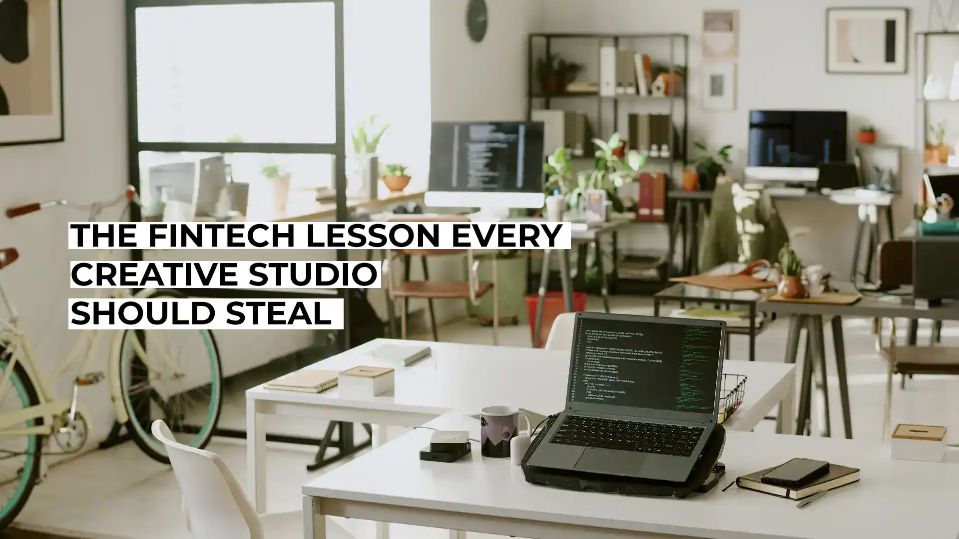 Modern creative studio with laptops, books, and plants for digital work.