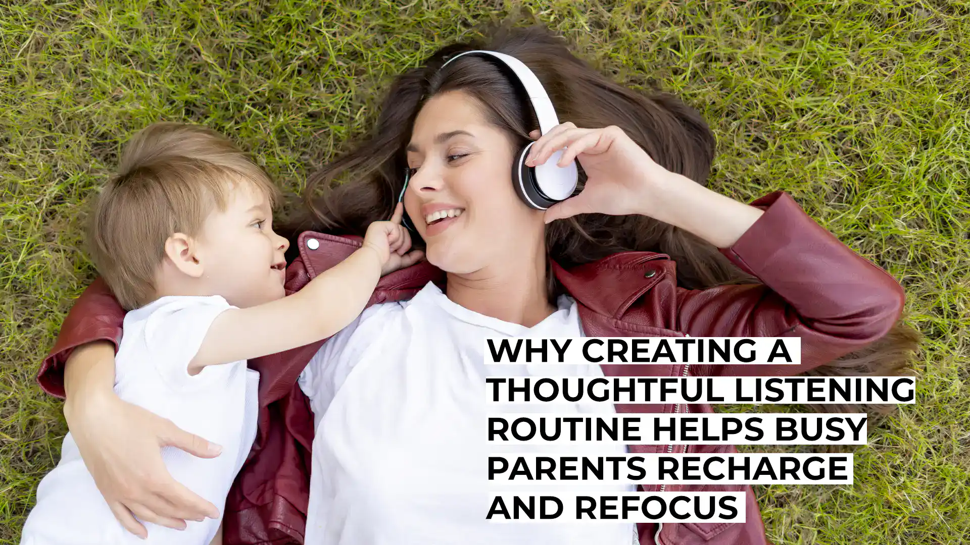 Mother and child listening to music with headphones on grass.