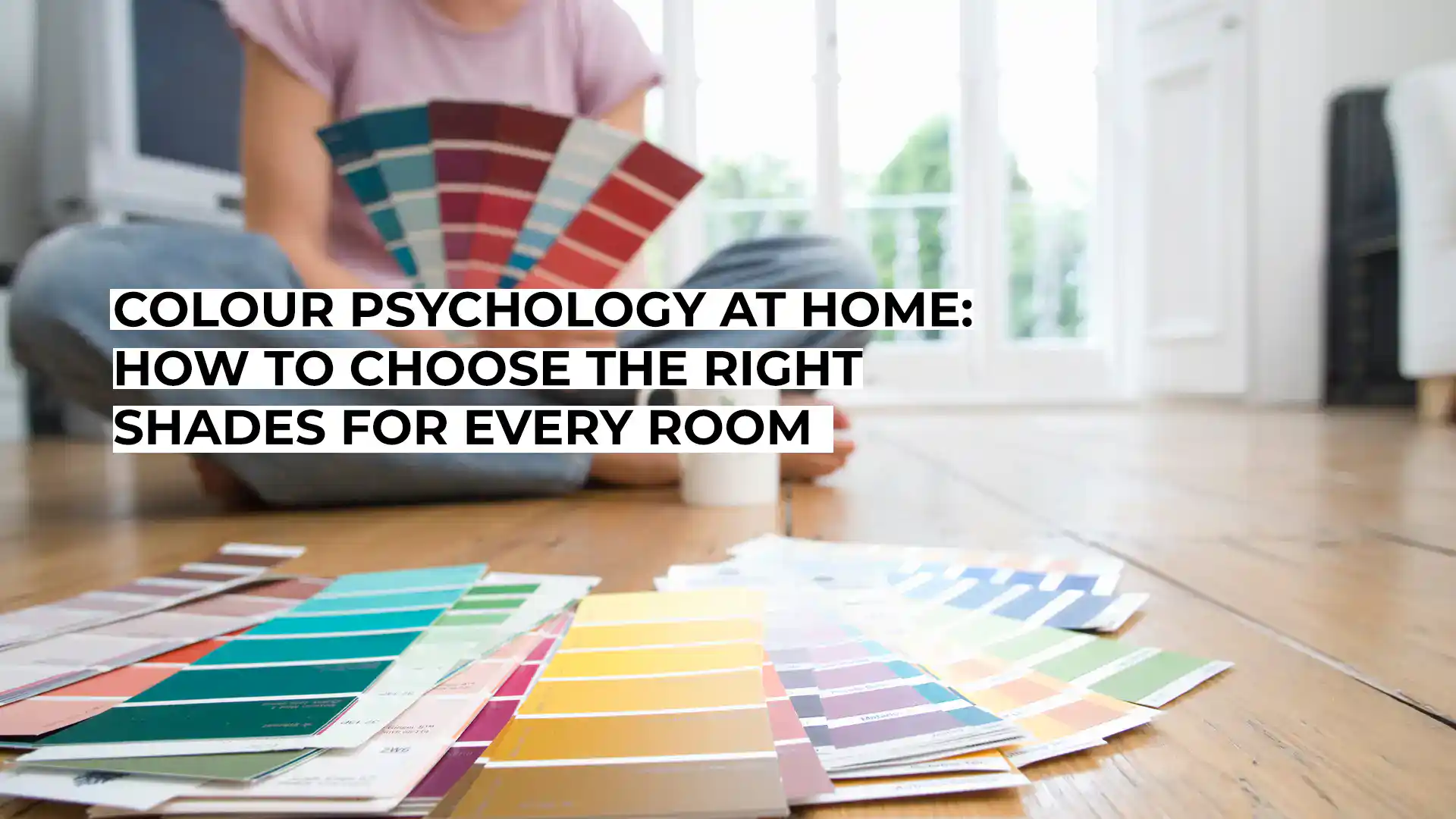 Person selecting paint colour swatches for home decor.
