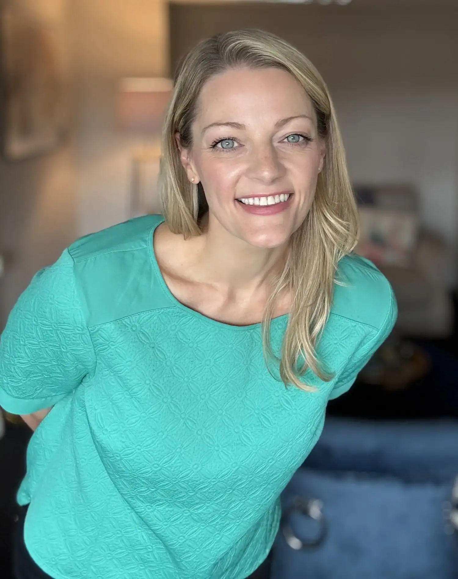 Smiling woman in turquoise top for Brood Magazine & Community.