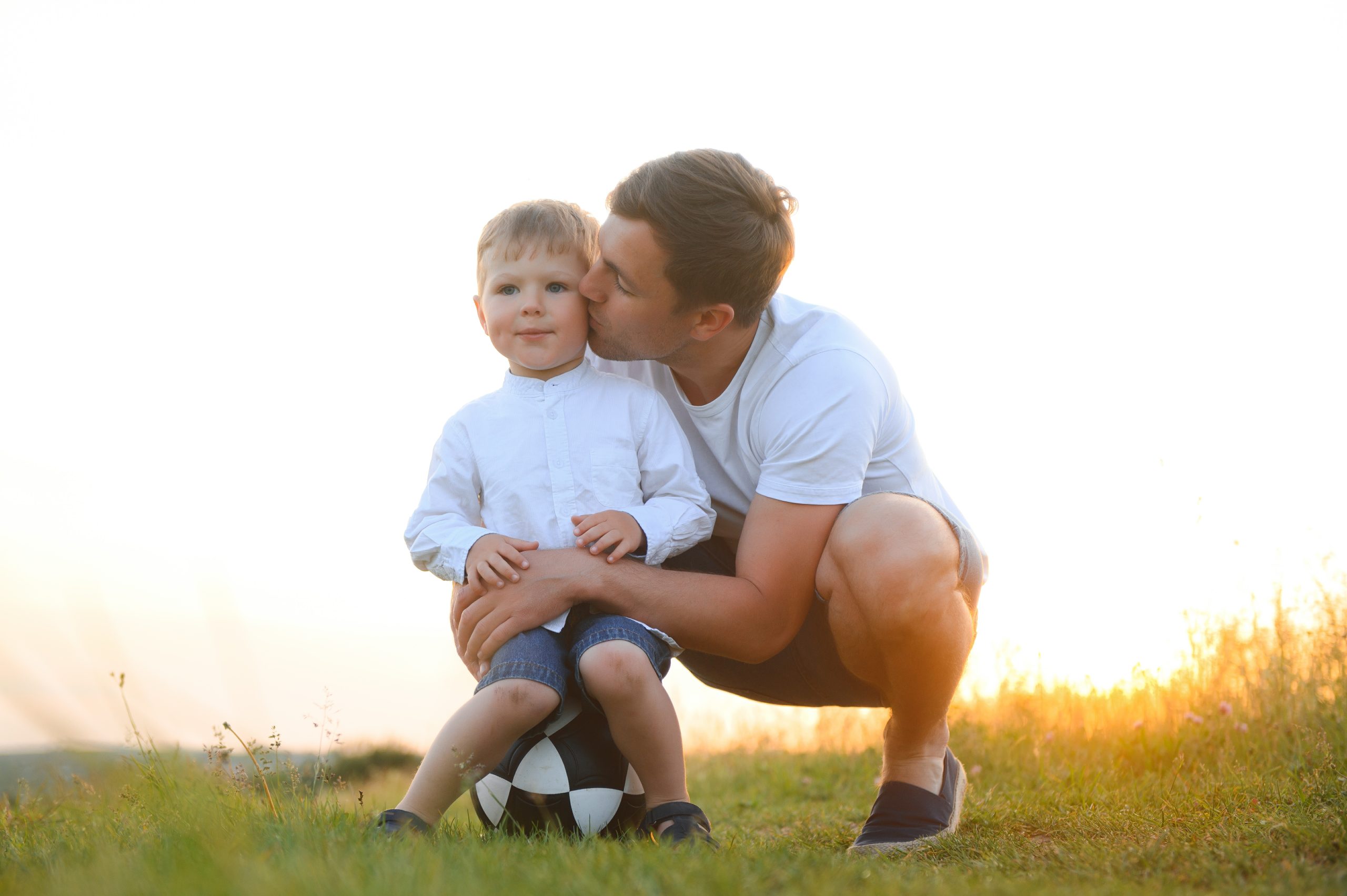 Loving father gently kissing his son outdoors