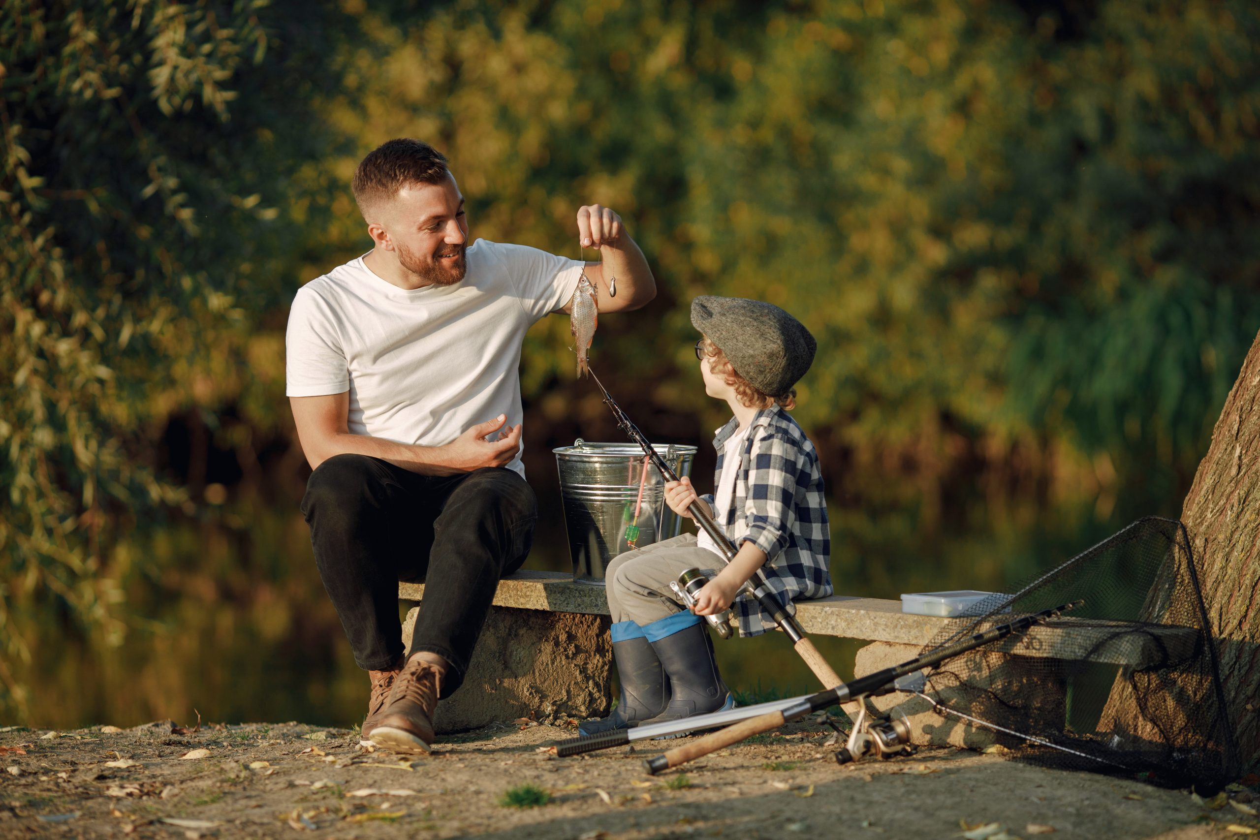 Man and child fishing by lake representing fatherhood and male role models