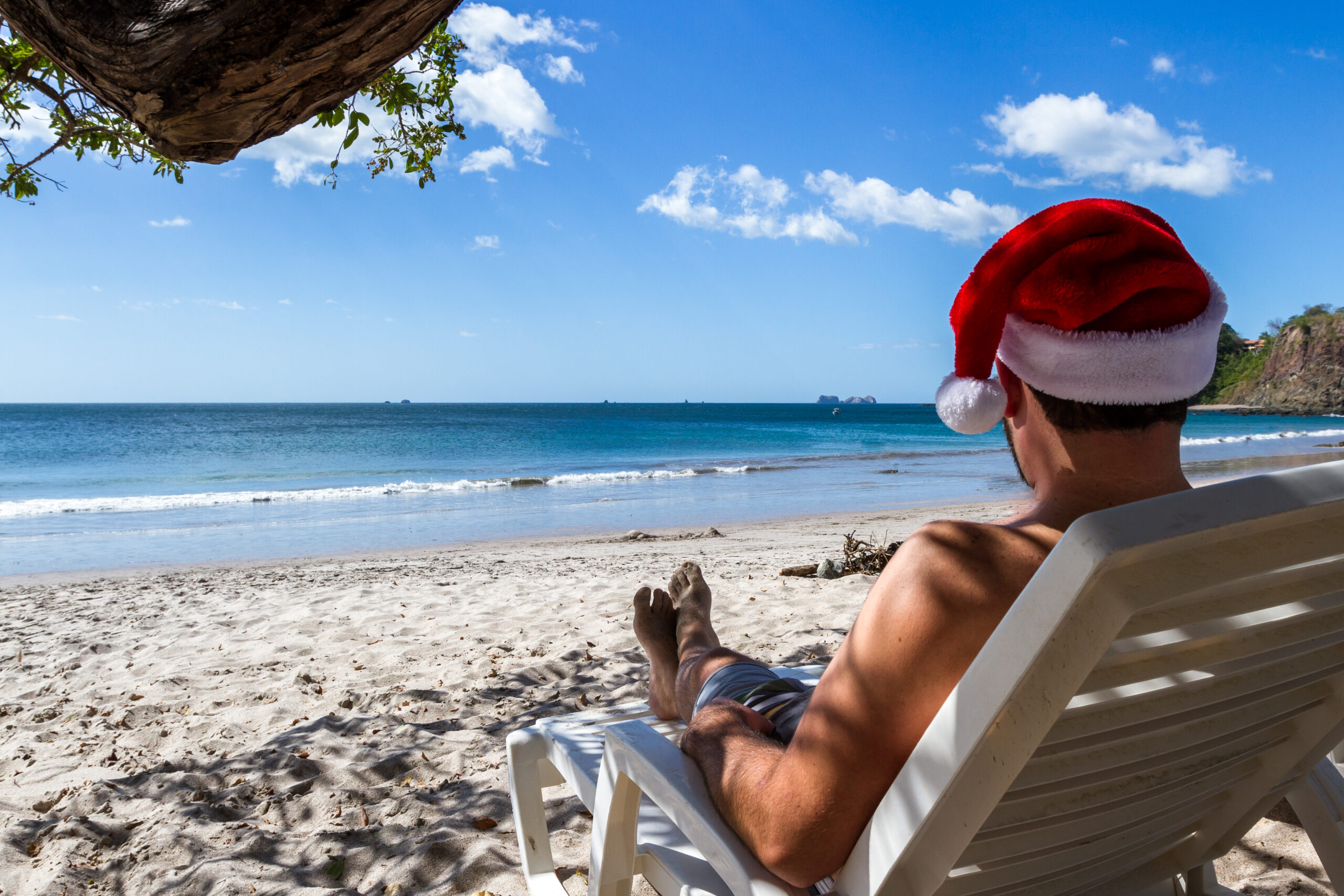 Holiday concept with a man wearing a Santa hat relaxing