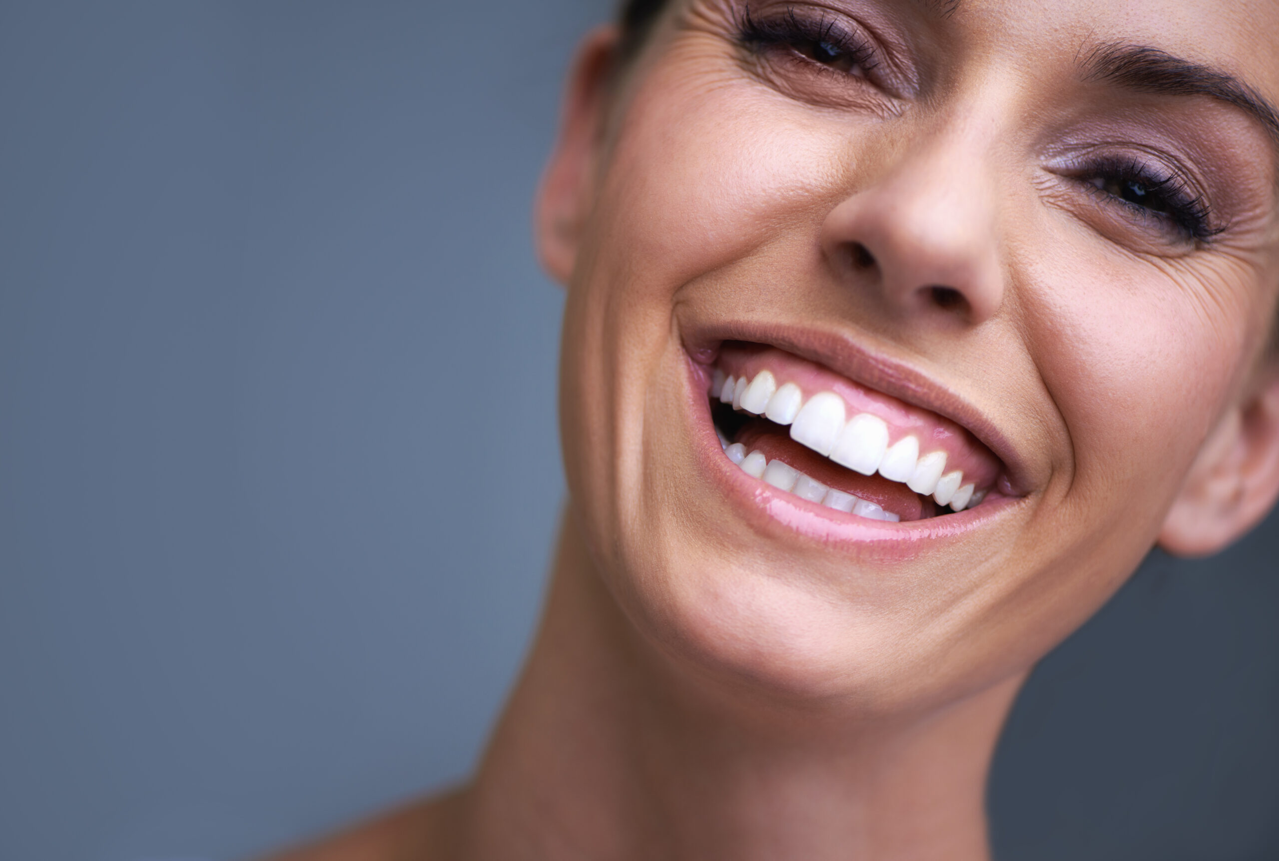 Smiling woman with natural white teeth close up
