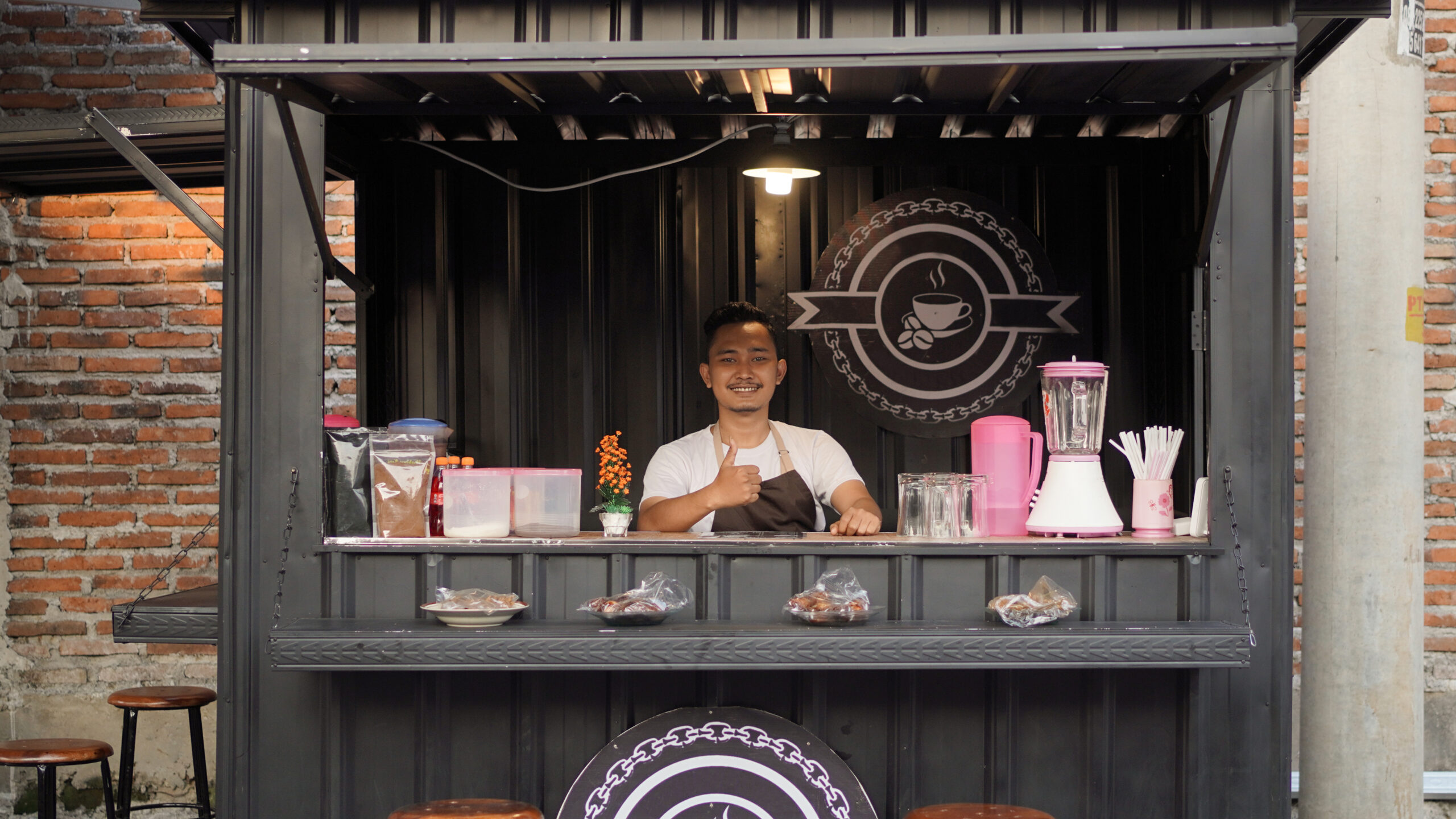 Young adult business owner smiling in a coffee shop setting